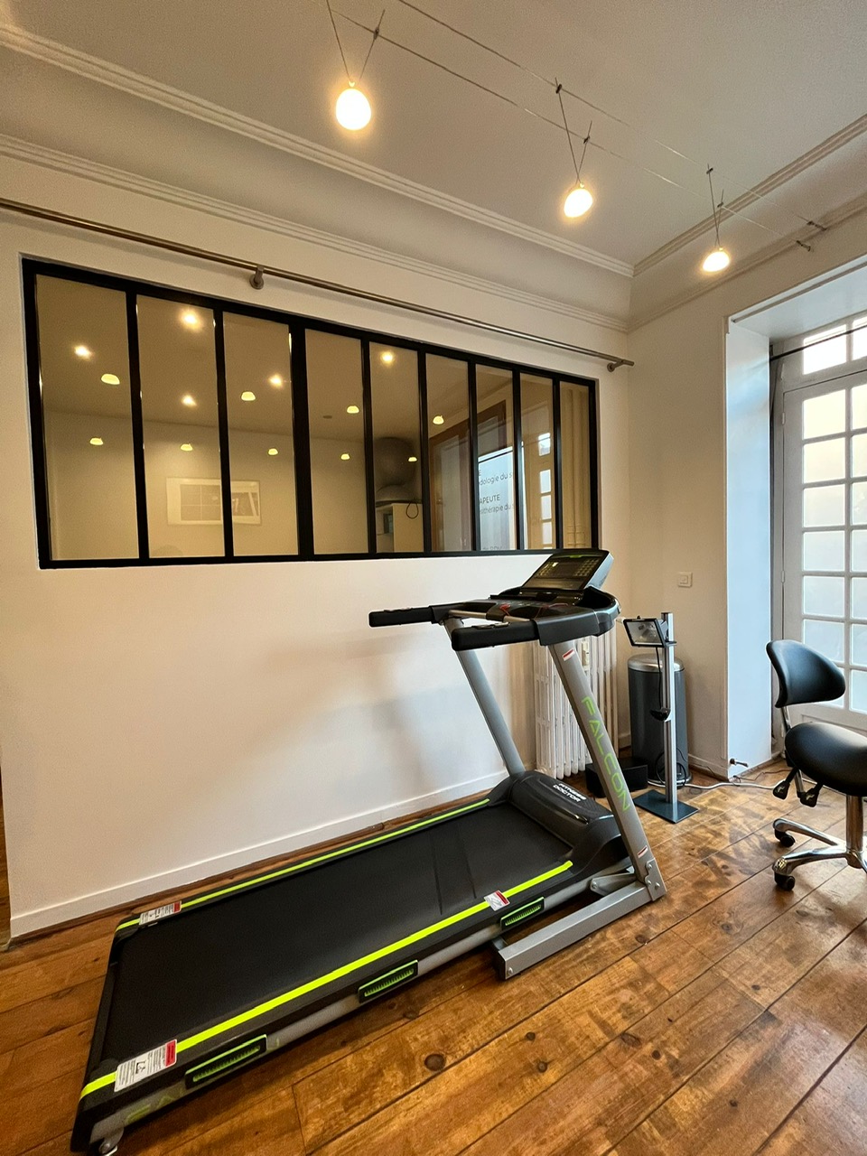 Cabinet de podologie — tapis de course, verrière, parquet, lumière naturelle